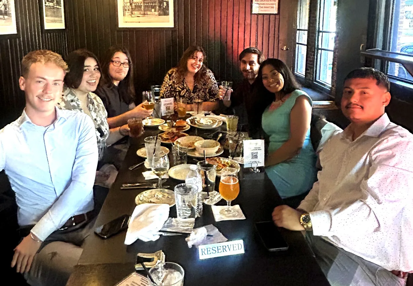 Miembros del equipo BluePeak Digital Insurance sentados juntos en una cena de equipo